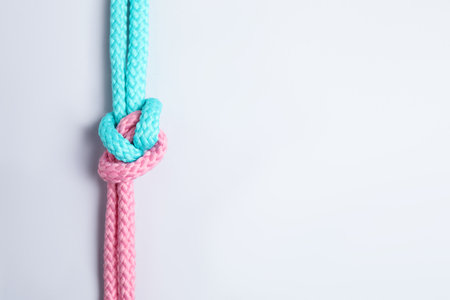 Colorful ropes tied together with knot isolated on white, top view. unity concept