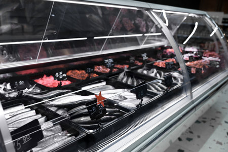 Showcase with different types of fresh fish in supermarket