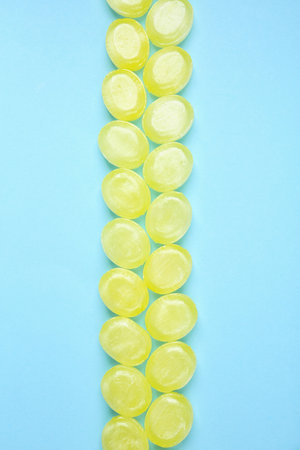Many delicious lemon drops on light blue background, flat layの写真素材