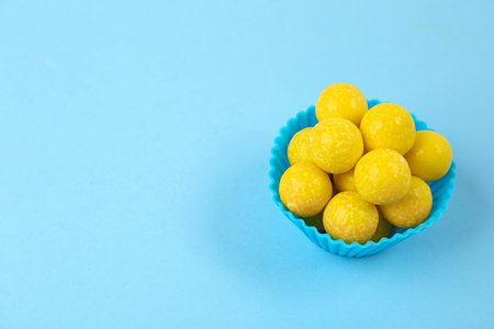 Delicious lemon chewing gums on light blue background. Space for textの写真素材