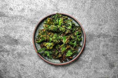 Tasty baked kale chips on gray table, top viewの写真素材