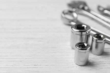Auto mechanic's tools on white wooden background, closeup. Space for text