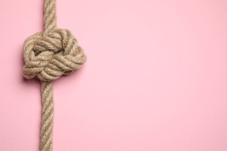 Top view of linen rope with knot on pink background, space for text. unity conceptの写真素材