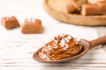 Salted caramel in spoon on white wooden table, closeupの写真素材