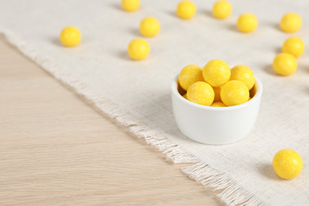 Tasty lemon drops on wooden table. Space for textの写真素材