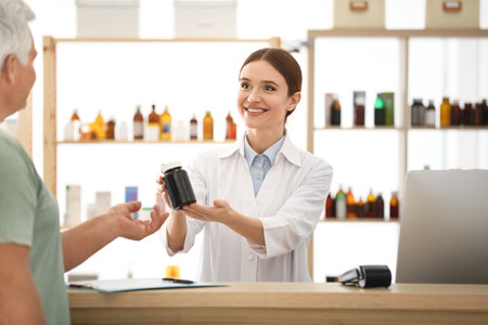 Pharmacist giving medicine to customer in drugstoreの写真素材