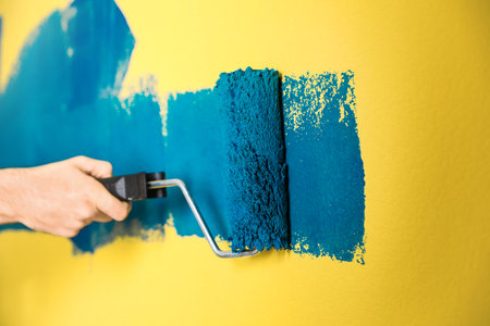 Man painting yellow wall with blue dye, closeupの写真素材