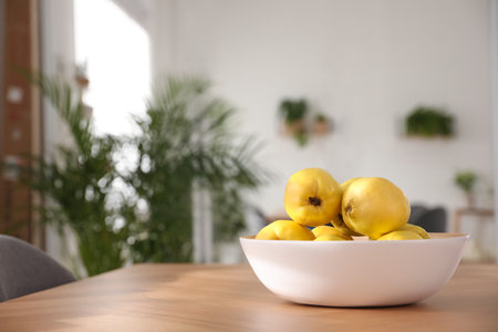 Ripe quinces on wooden table at homeの写真素材