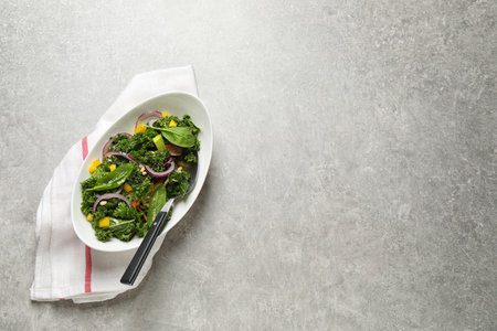 Tasty fresh kale salad on light gray table, top viewの写真素材
