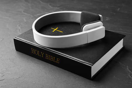 Bible and headphones on black background. religious audiobook