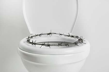 Toilet bowl with barbed wire on white background. Hemorrhoid conceptの写真素材