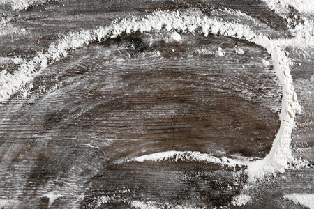 Flour on wooden table, top view. Space for text