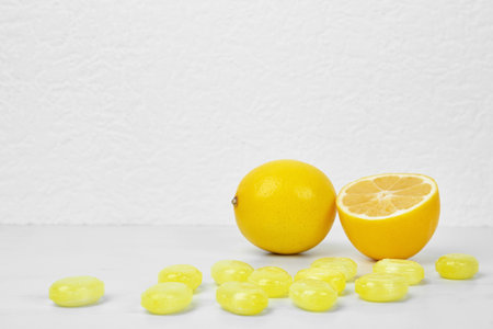 Fresh lemon and tasty drops on white tableの写真素材