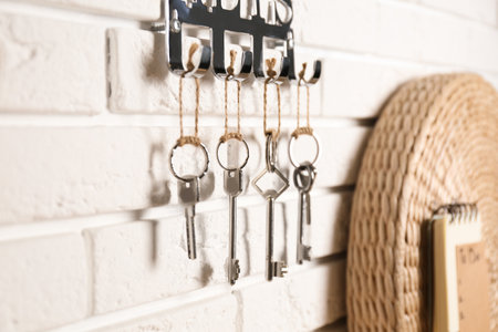 Metal key holder on white brick wall indoors, closeupの写真素材