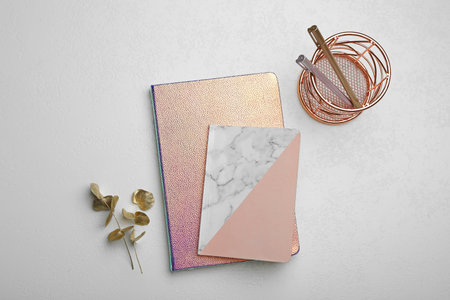 Stylish notebooks and decor elements on white table, flat layの写真素材