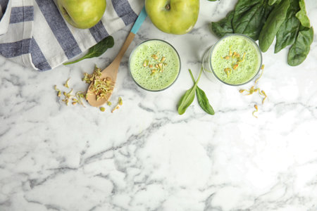 Flat lay composition with green buckwheat smoothie on white marble table, space for textの写真素材