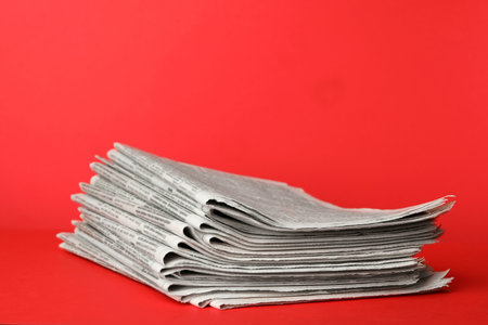 Stack of newspapers on red background. Journalist's workの写真素材
