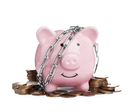 Piggy bank with steel chain and coins isolated on white. money safety conceptの写真素材