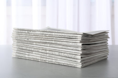 Stack of newspapers on light gray table. Journalist's workの写真素材