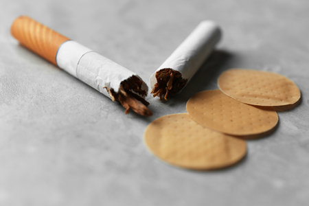 Nicotine patches and broken cigarettes on gray table, closeupの写真素材
