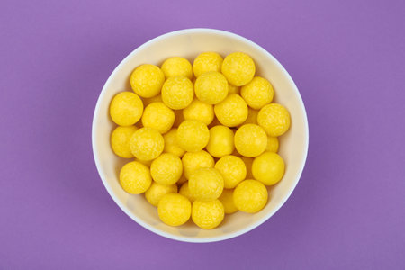 Delicious lemon drops on purple background, top viewの写真素材