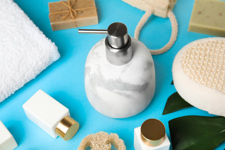 Marble soap dispenser and toiletries on light blue background