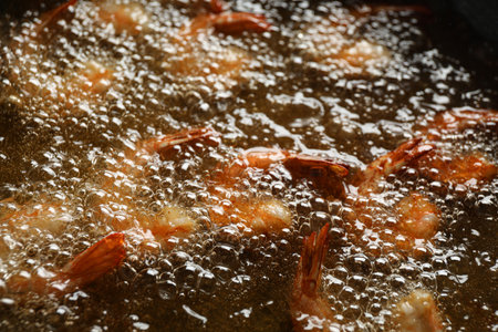 Cooking delicious shrimps in hot oil, closeupの写真素材