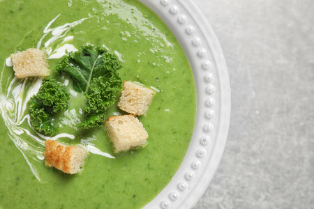 Tasty kale soup with croutons on gray table, top viewの写真素材