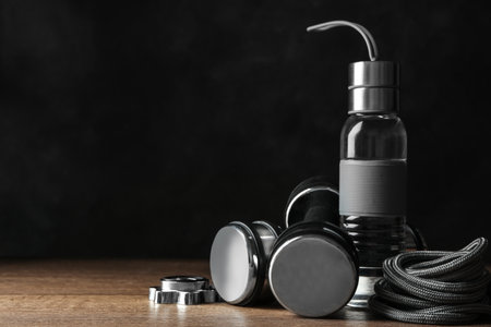 Gym equipment and accessories on floor against dark background. Space for textの写真素材