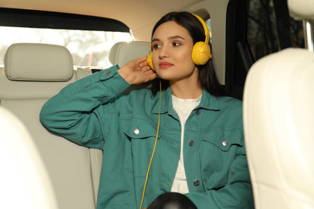 Young woman listening to audiobook in car
