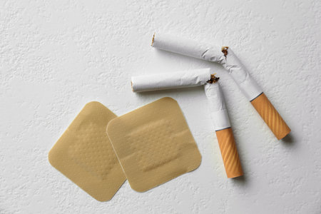 Nicotine patches and broken cigarettes on white background, flat layの写真素材