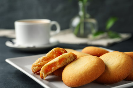 Tasty shortbread cookies with filling on black table, closeupの写真素材