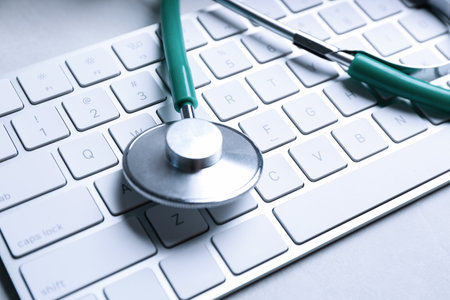 Keyboard and stethoscope on gray table, closeup. Concept of technical supportの写真素材