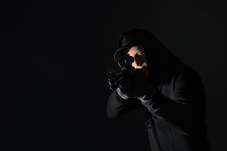Professional killer with sniper rifle on black backgroundの写真素材