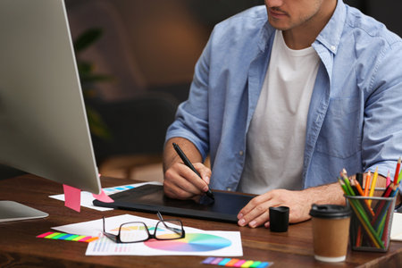 Male designer working at desk in office, closeupの写真素材