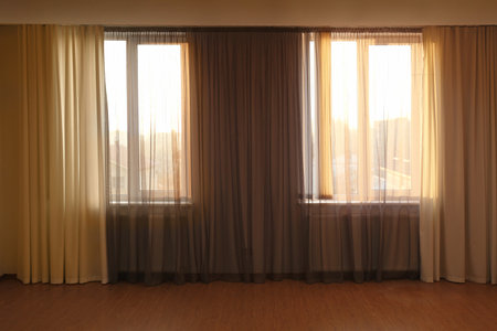 Windows with beautiful curtains in empty roomの写真素材