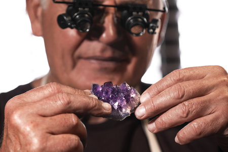 Professional jeweler working with beautiful amethyst, closeup