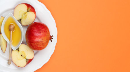 Honey, apples and pomegranate on orange background, top view. with space for text Rosh Hashanah holidayの写真素材