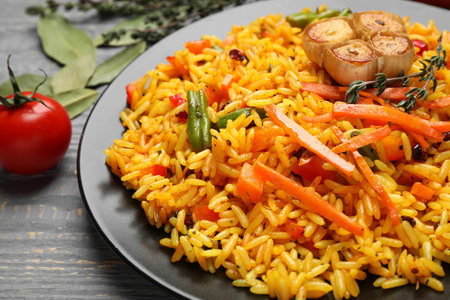 Tasty rice pilaf with vegetables on gray wooden table, closeupの写真素材