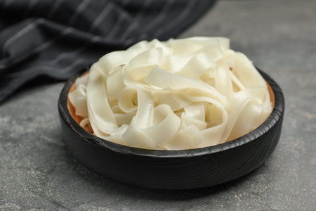 Tasty cooked rice noodles on gray table, closeup