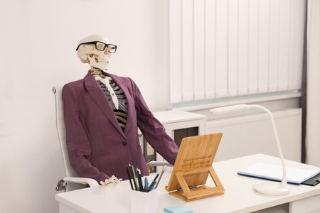 human skeleton in suit at table in officeの写真素材