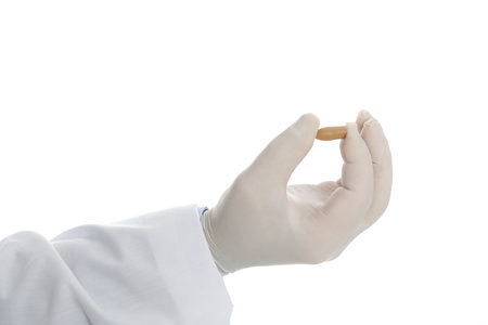 Doctor holding suppository for hemorrhoid treatment on white background, closeupの写真素材