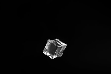 Crystal clear ice cube on black background