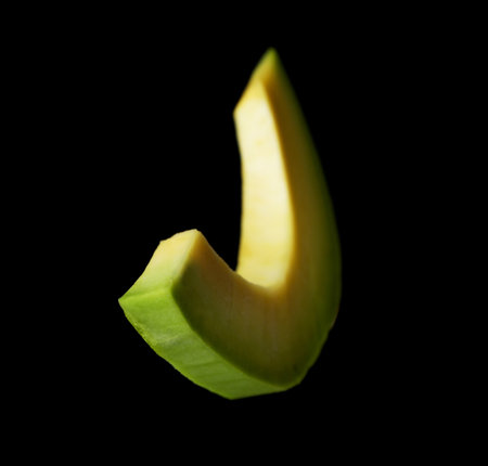 Slice of fresh avocado on black backgroundの写真素材
