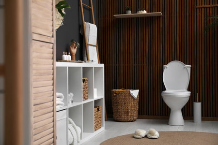 Elegant modern bathroom with toilet bowl near wooden wallの写真素材