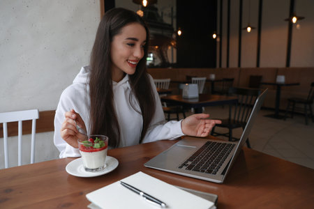 Young blogger working with laptop in cafe