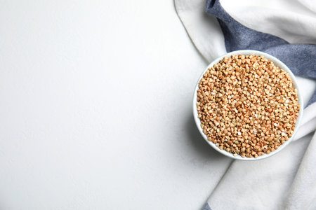 Bowl with green buckwheat on white table, top view. Space for textの写真素材