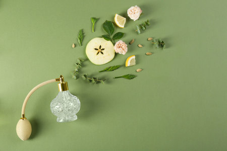 Flat lay composition with bottle of perfume on green background, space for text