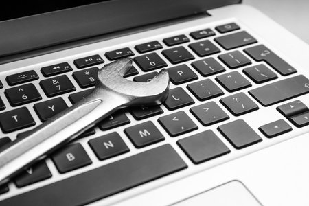 Spanner on laptop, closeup. Concept of technical support