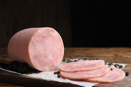 Tasty ham with thyme and pepper on wooden table